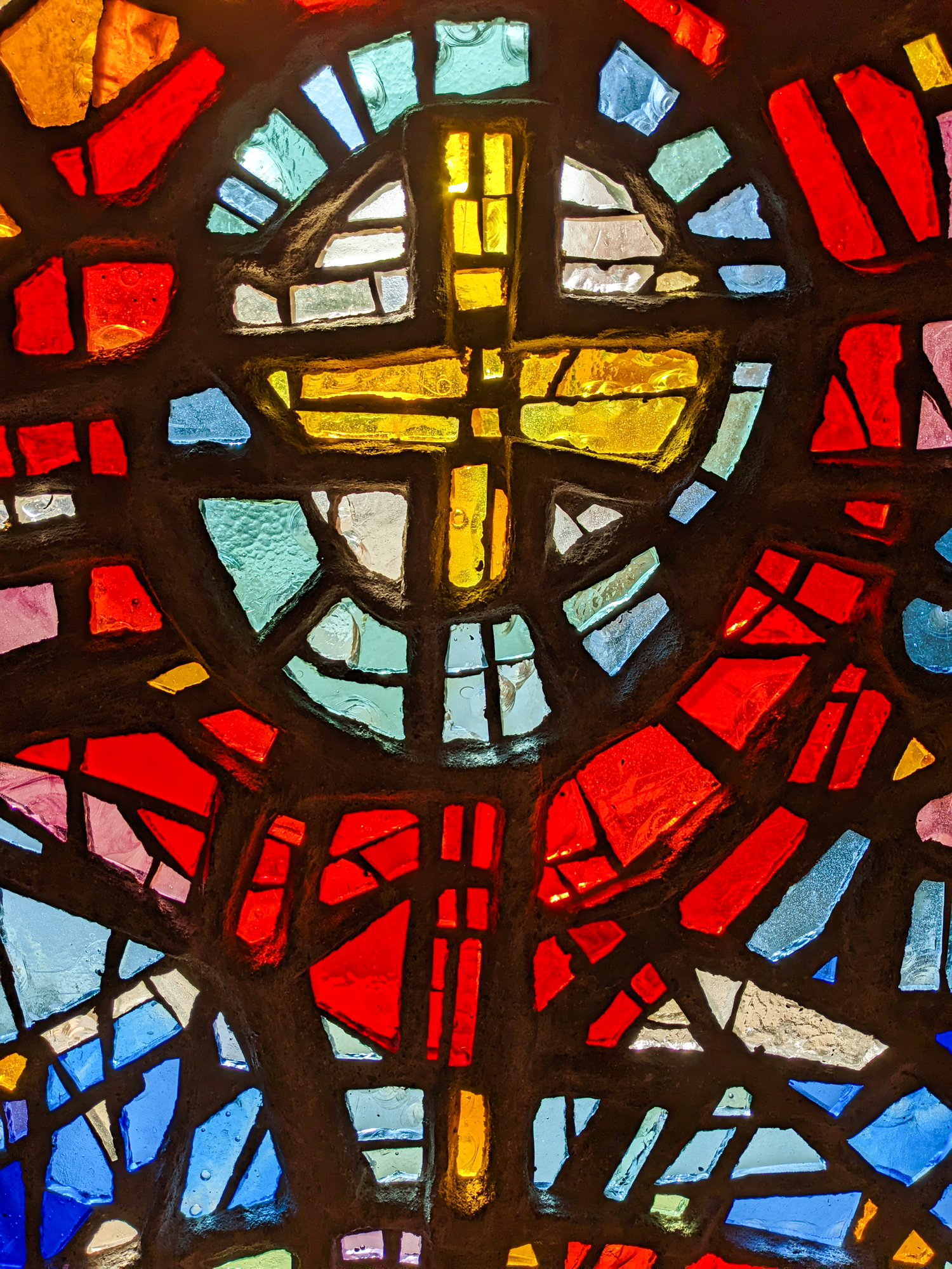 Window in the church, stained glass, colored mosaic in the form of a cross