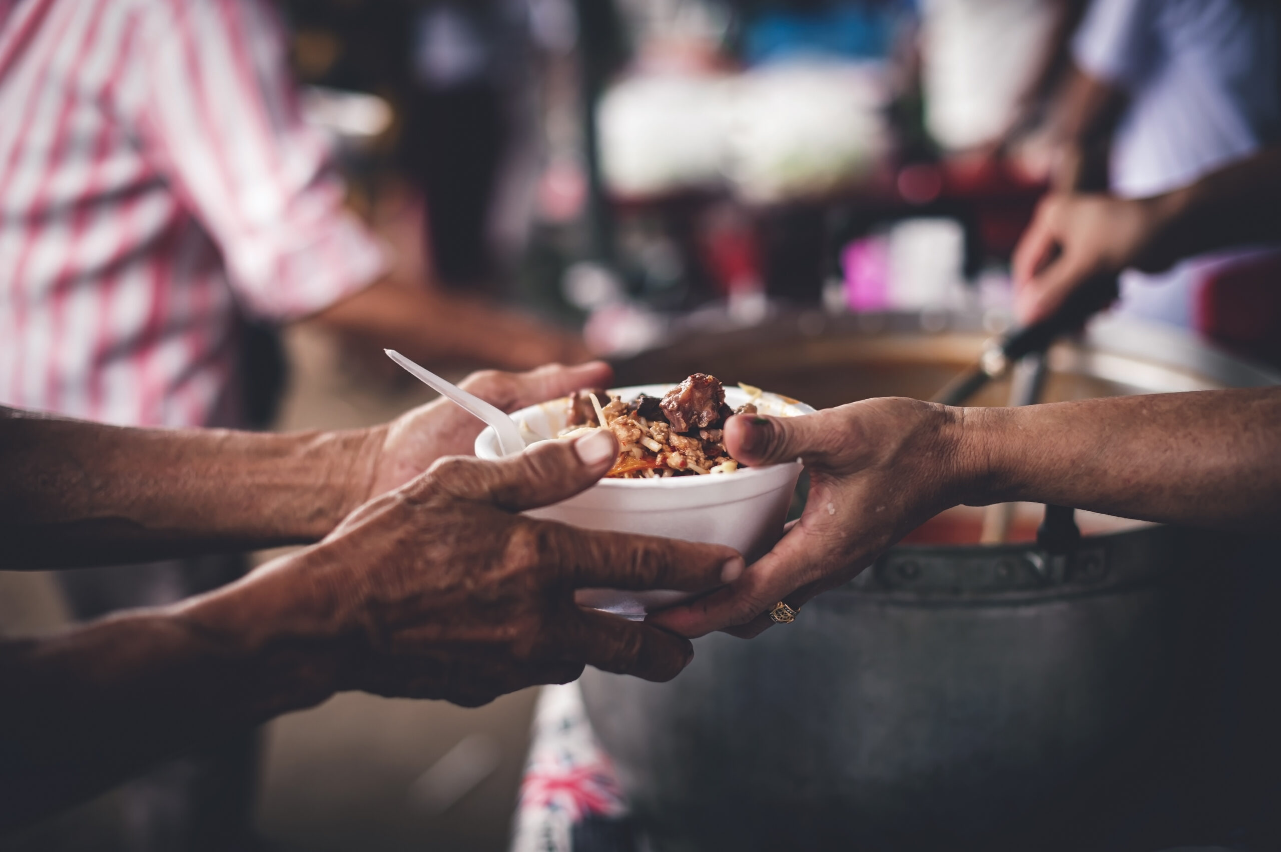 Concept of giving free food to the poor in the community : Volunteers handing out food to hungry people